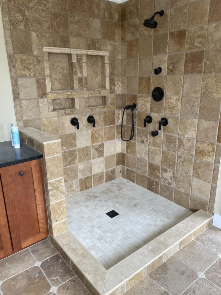 Travertine walk-in shower with custom niches by Peter's Tile