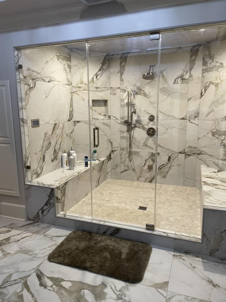 Marble shower with glass enclosure by Peter's Tile