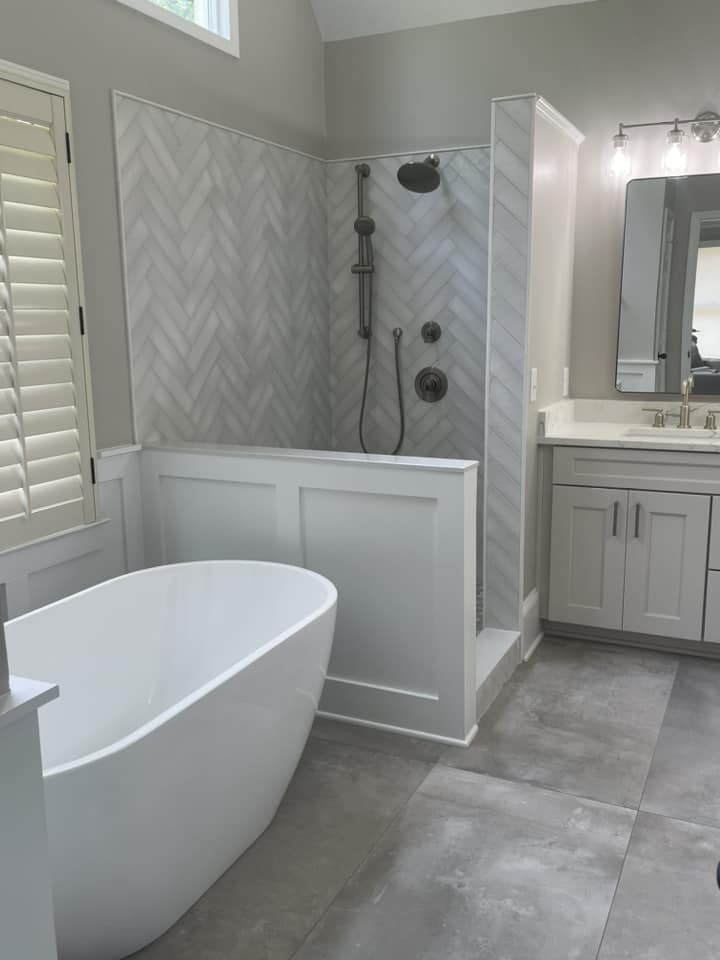 Herringbone marble shower with freestanding tub by Peter's Tile