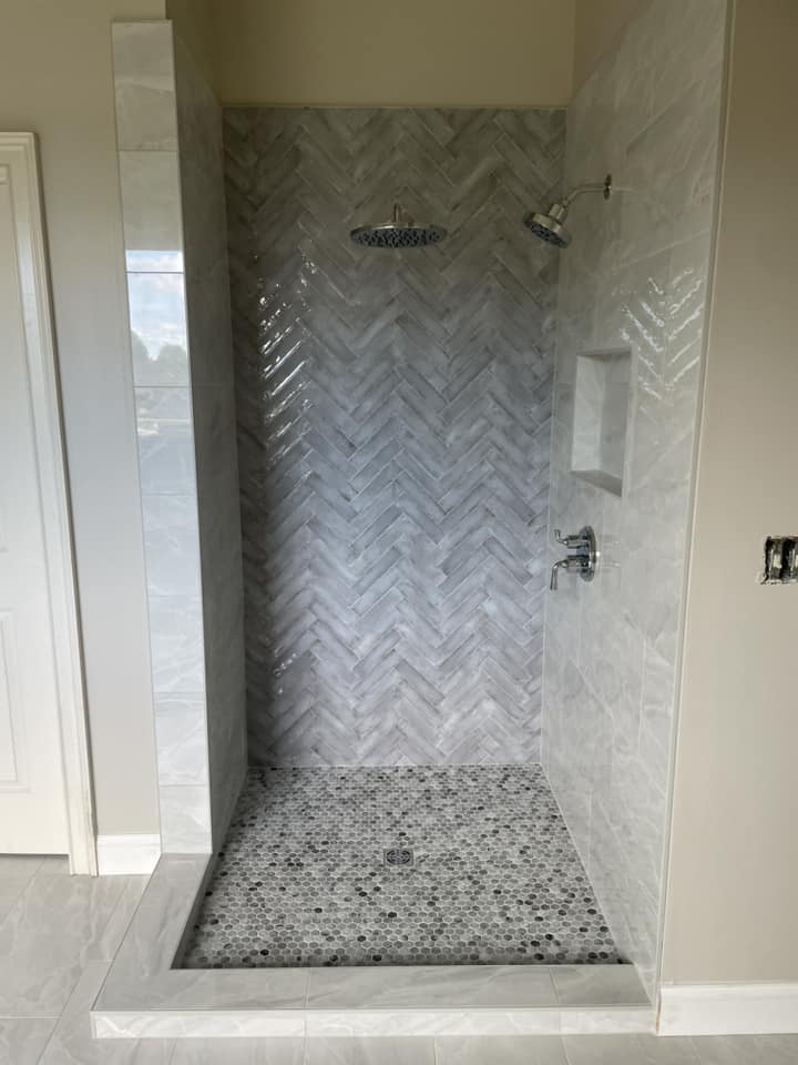 Herringbone marble shower stall with penny floor by Peter's Tile