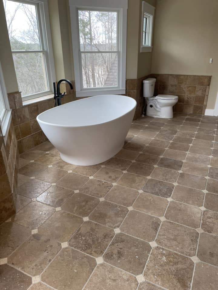Bathroom with freestanding tub and travertine octagon floor by Peter's Tile