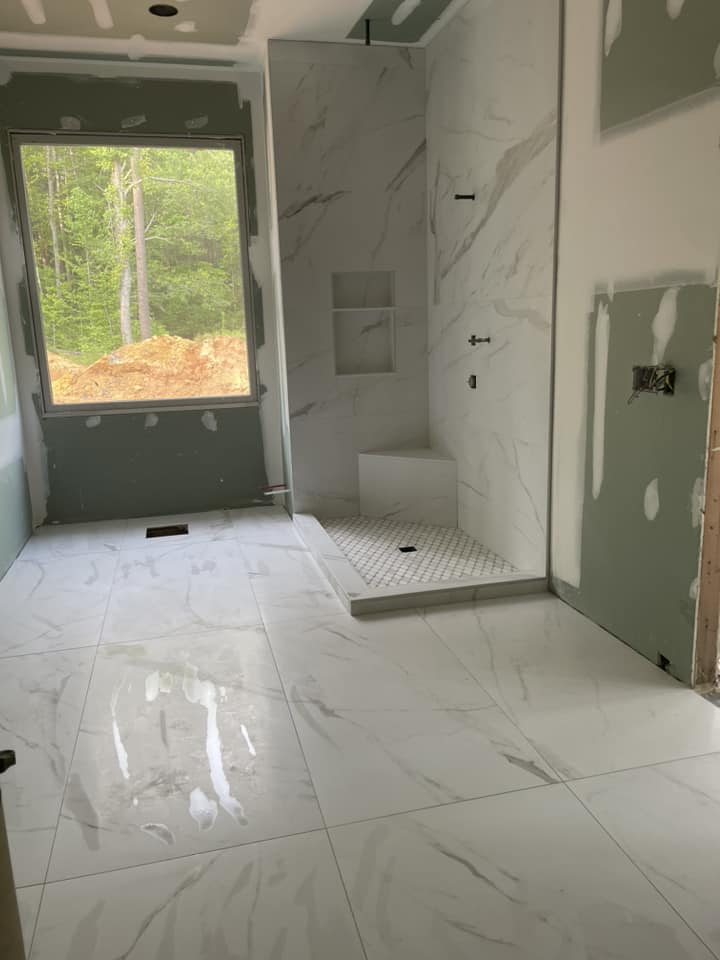 Marble shower stall with large-format marble floor by Peter's Tile