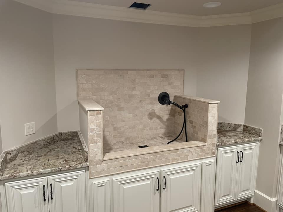 Custom travertine tile basin with granite countertops by Peter's Tile