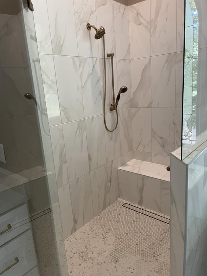 Marble shower with built-in bench by Peter's Tile